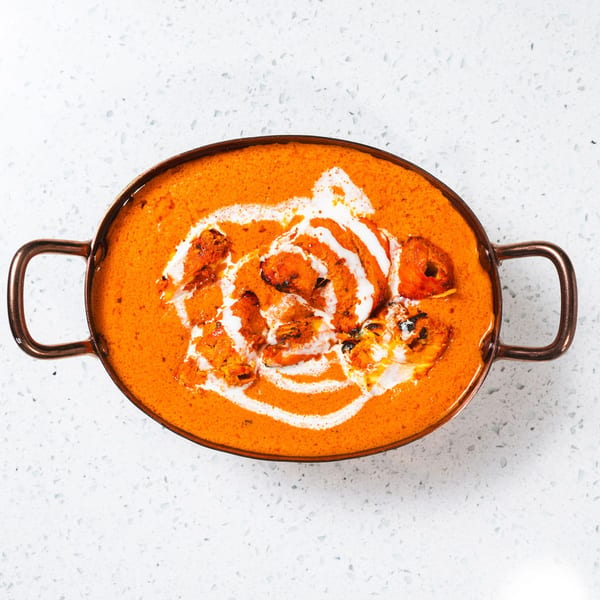 Gulab Indian Bistro's chicken tikka masala, a vibrant orange curry with chicken pieces and cream swirls.